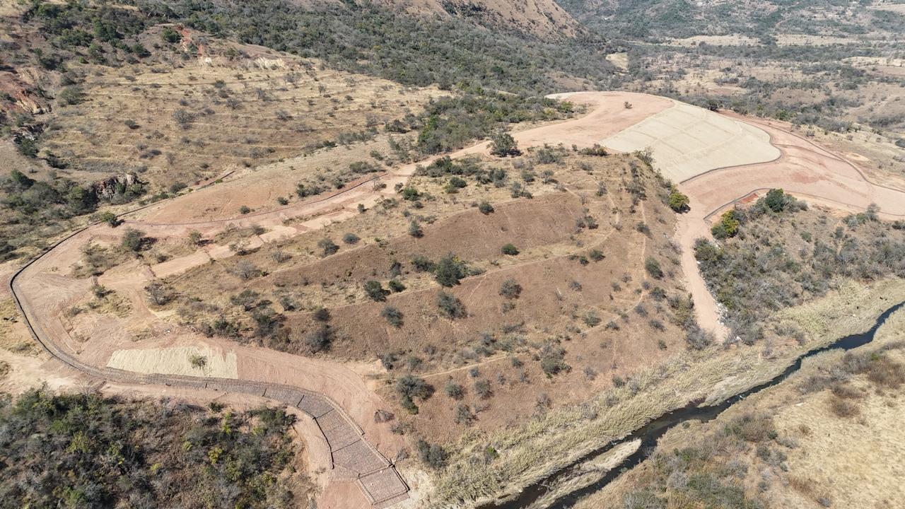 Aerial view of a long PVC coated gabion wall along a road above a river at Badplaas